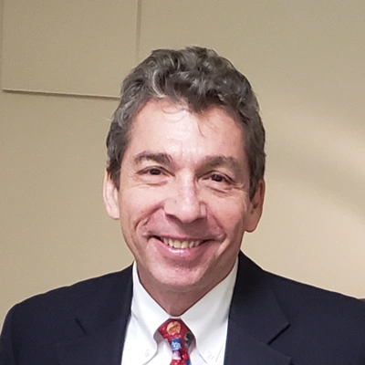 Professional headshot of an eye doctor in formal attire