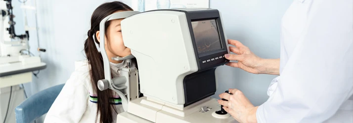 Person looking into an autorefractor machine during an eye exam