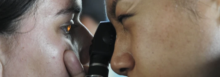Close-up of two people facing each other during an eye examination